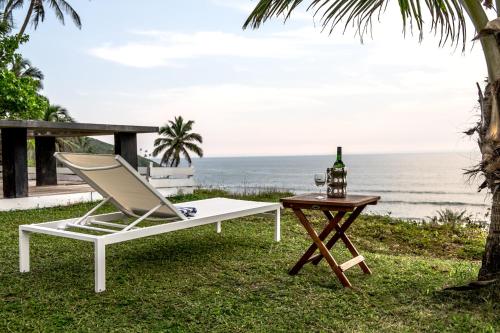a white lounge chair and a table with a bottle of wine at Casa Vagator in Vagator