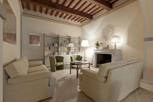 a living room with two chairs and a fireplace at VillAmorosa in Calci