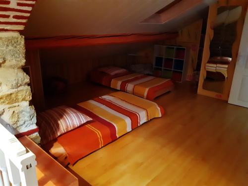 two beds in a room with wood floors at LA PROVIDENCE, chambres d'hôtes in Saint-Sernin-du-Plain