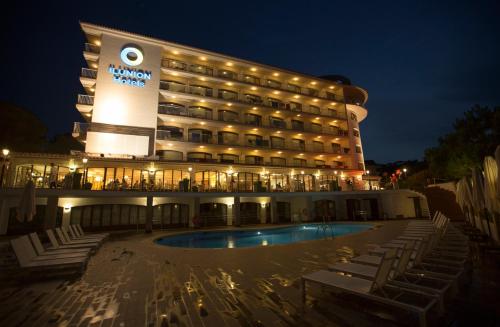 a hotel with a swimming pool in front of a building at Ilunion Caleta Park in Sant Feliu de Guixols