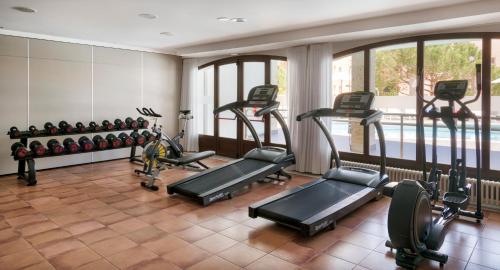 a gym with several treadmills and elliptical machines at Ilunion Caleta Park in Sant Feliu de Guixols