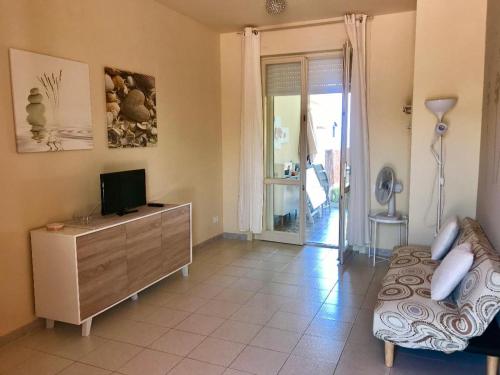 a living room with a tv and a dresser with a television at Casa Limone in Quartu sant Elena, Capitana, with sea view! in Capitana