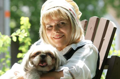 a woman sitting on a chair with a dog at Refuge du Poète in Longueuil