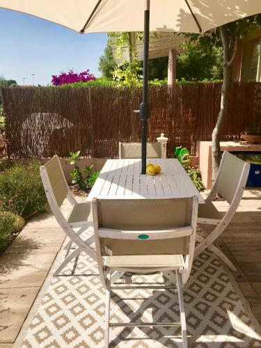 a white table and chairs with an umbrella at Casa Limone in Quartu sant Elena, Capitana, with sea view! in Capitana