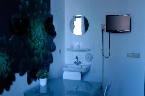 TV y baño con lavabo y aseo. en Rembrandt Square Hotel, en Ámsterdam