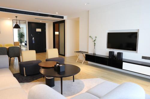 a living room with a couch and a flat screen tv at Citadines Gaoke Liangjiang Chongqing in Chongqing