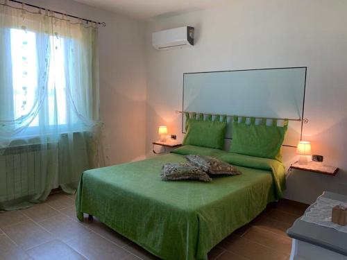 フォイアーノ・デッラ・キアーナにあるIl Falcoのベッドルーム(緑のベッド1台、窓付)