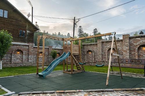a playground with a slide in a yard at VILA NORBE in Buşteni
