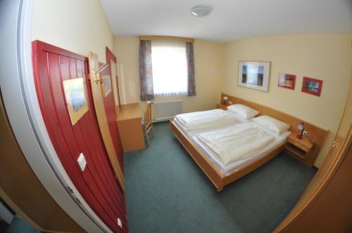 a bedroom with a bed and a red door at Apparthotel Bliem in Schladming