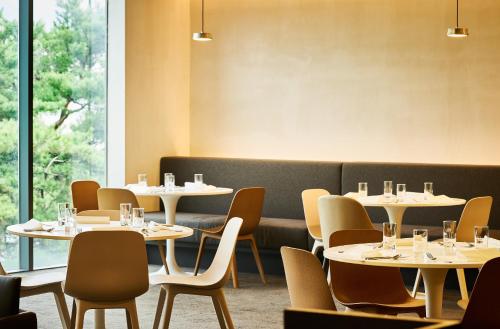 a dining room with tables and chairs and a couch at Phoenix Hotel Pyeongchang in Pyeongchang 
