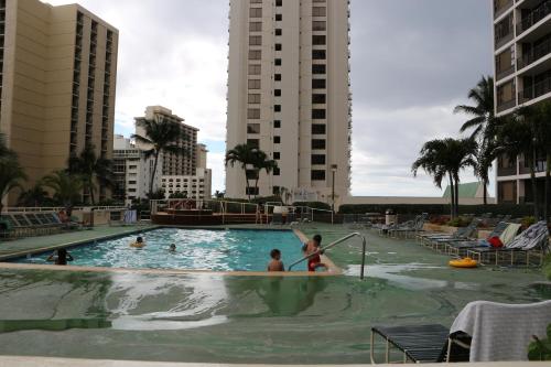 a couple of people in a swimming pool at Waikiki Banyan T1-3204 in Honolulu
