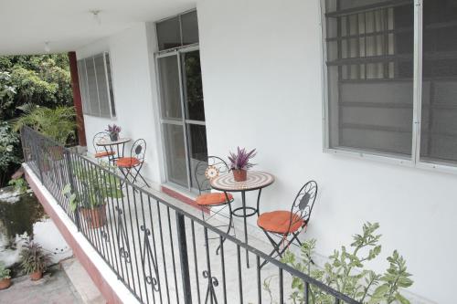 a balcony with chairs and a table and windows at Hotel Posada del Angel in Mérida