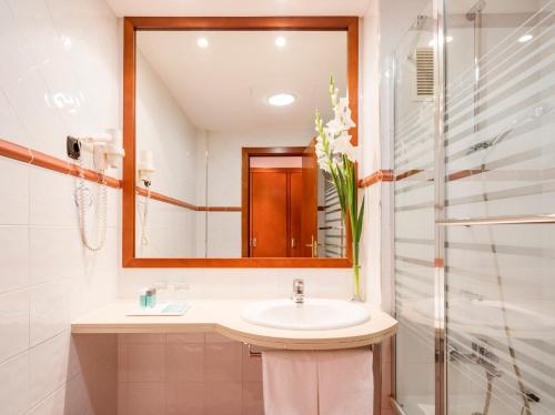 
a bathroom with a sink and a mirror at Ilunion Caleta Park in Sant Feliu de Guíxols
