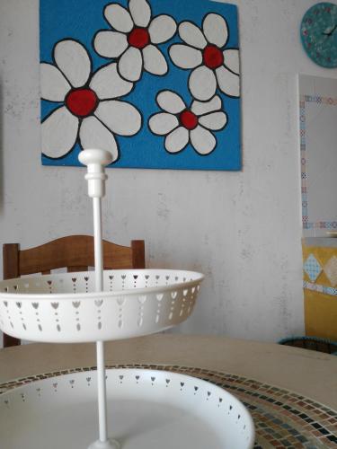a white plate on a table with a flower painting at Casa GIOLE in Punta Secca