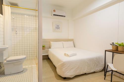 a bathroom with a bed and a toilet in a room at Minima 8 in George Town