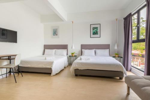 a bedroom with two beds and a table at Minima 8 in George Town