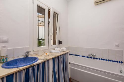 a bathroom with a blue sink and a tub at Hotel Los Castaños in Cartajima