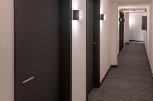 a hallway with black and white doors and carpet at GHT Miratge - Only Adults 18 and up in Lloret de Mar