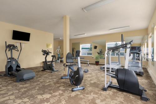 a gym with several treadmills and elliptical machines at Nova Inn Yellowknife in Yellowknife