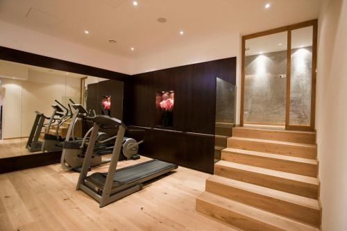 a gym with tread machines and stairs in a house at Hotel Gräfrather Hof in Solingen