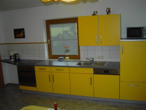 a kitchen with yellow cabinets and a sink at Appartement Pichler in Radstadt