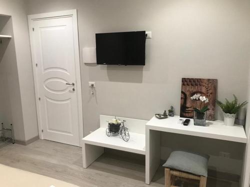 - un salon blanc avec une télévision murale dans l'établissement TaoZen Apartments, à Taormine