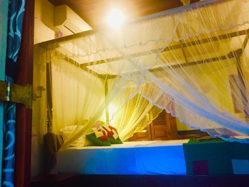 a bedroom with a bed with a mosquito net at Goyambokka Guesthouse in Tangalle