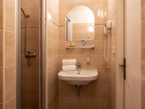 bagno con lavandino e specchio di Novoměstský hotel a Praga
