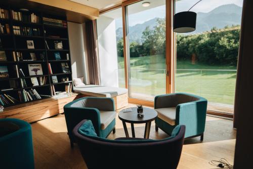 a living room with chairs and a table and a window at Klosterhof – Alpine Hideaway & Spa in Bad Reichenhall