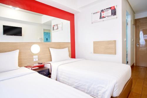a hotel room with two beds and a tv at Red Planet Davao in Davao City