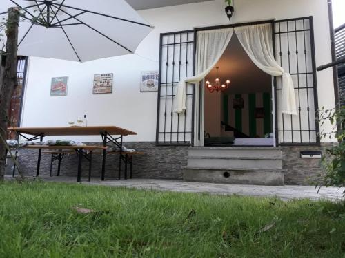 a table and an umbrella in front of a house at Il Giardino Del Nespolo in Arcola