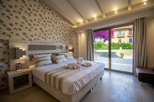 een slaapkamer met een groot bed met twee poppen erop bij Paradise Apartments in Laganas