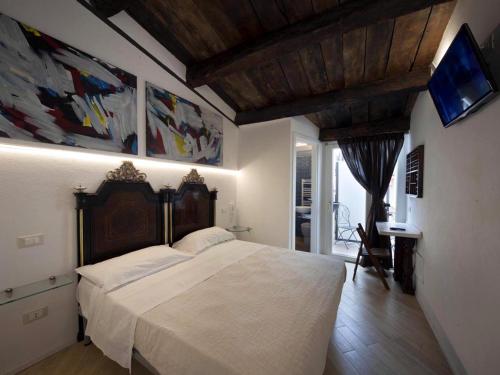 una camera da letto con un grande letto bianco e una televisione di Residenze Portacastello a Isernia