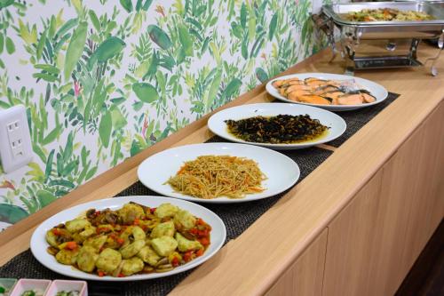 a buffet with four plates of food on a table at Hotel Mystays Nayoro in Nayoro