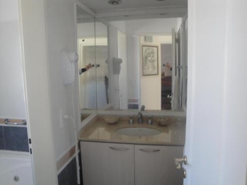 ein Badezimmer mit einem Waschbecken und einem großen Spiegel in der Unterkunft Duplex Barrancas in Puerto Madryn