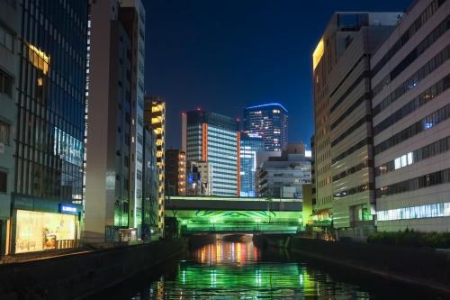 a river in the middle of a city at night at Super Hotel Premier Akihabara in Tokyo
