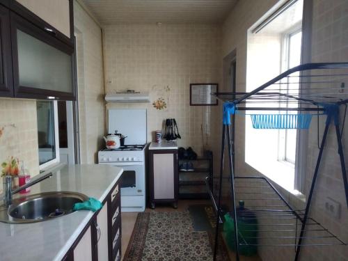 uma cozinha com um lavatório e um fogão forno superior em Samia House Room on Furqat 8 em Tashkent