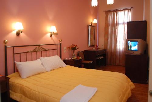 a hotel room with a bed and a television at Allotino Pension in Nafplio