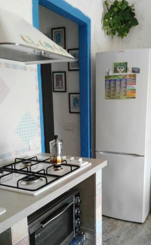 a kitchen with a stove top oven next to a refrigerator at Casa GIOLE in Punta Secca