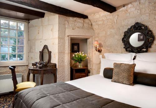 um quarto com uma cama grande e um espelho em Hôtel Saint-Martin - La Maison Younan em Saint-Maixent-lʼÉcole