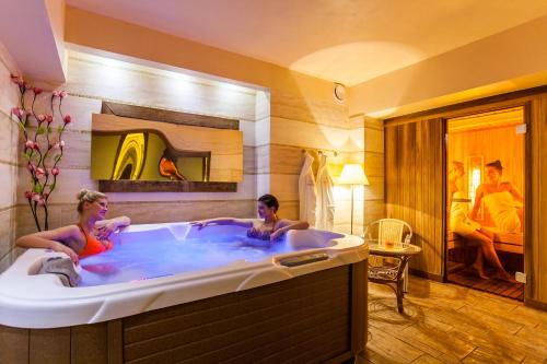 two people in a bath tub in a hotel room at Hotel Albatros in Serwy