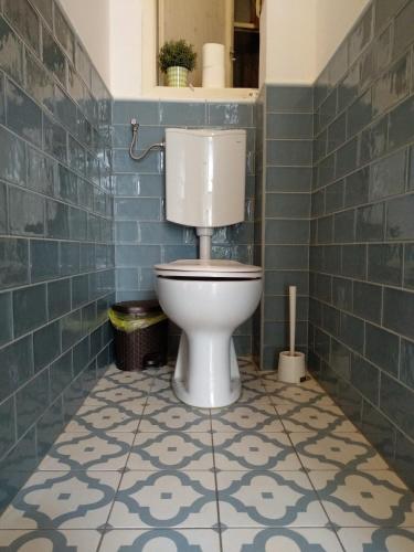 a bathroom with a toilet in a blue tiled bathroom at HoBar Hostel in Budapest