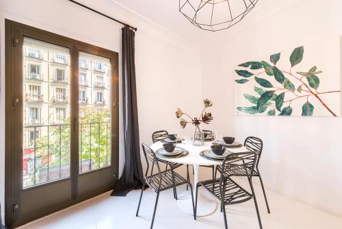 a dining room with a table and chairs and a window at Genteel Home Chueca in Madrid