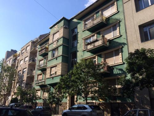 un edificio verde con coches aparcados delante de él en Budapest A+ Apartment, en Budapest