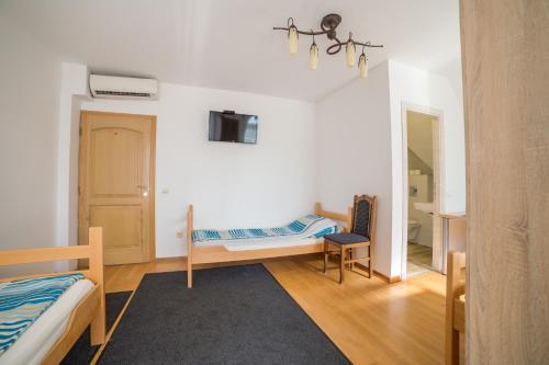 a room with two beds and a table and a mirror at Villa Ami in Novi Sad