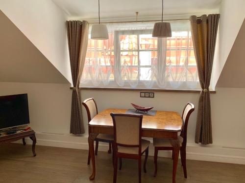 a dining room with a table and chairs and a television at Very Vilnius Pilies street in Vilnius