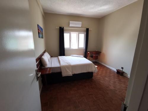Habitación pequeña con cama y ventana en TD Guest House 1 en Chimoio