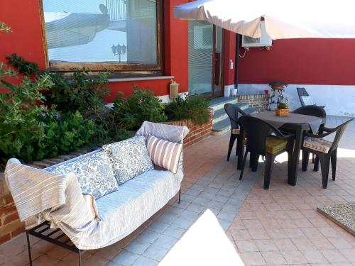 a couch sitting on a patio with a table at Cascina Roella in Monforte dʼAlba