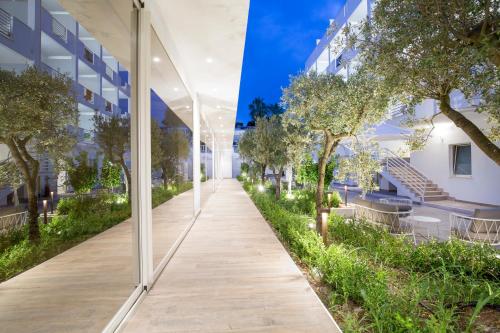 an external view of a corridor of a building with trees at Forte 2 Hotel in Vieste