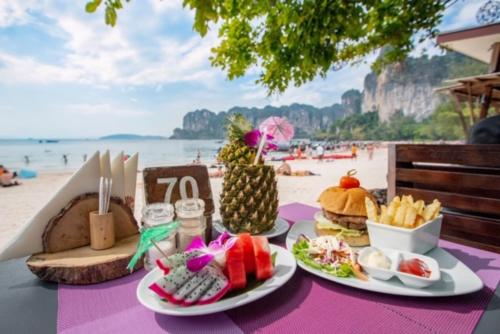 a table with plates of food on the beach at Railay Bay Resort & Spa in Railay Beach